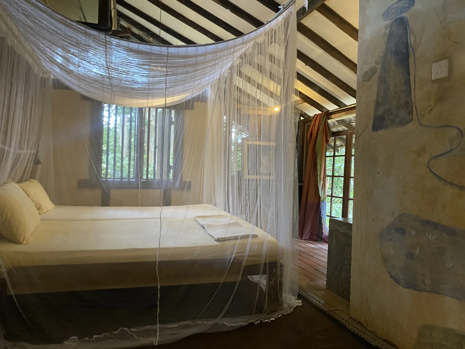 A bedroom under its mosquito net in the first bungalow