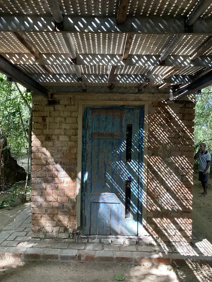 A reclaimed blue door beneath the shade of corrugated sheeting