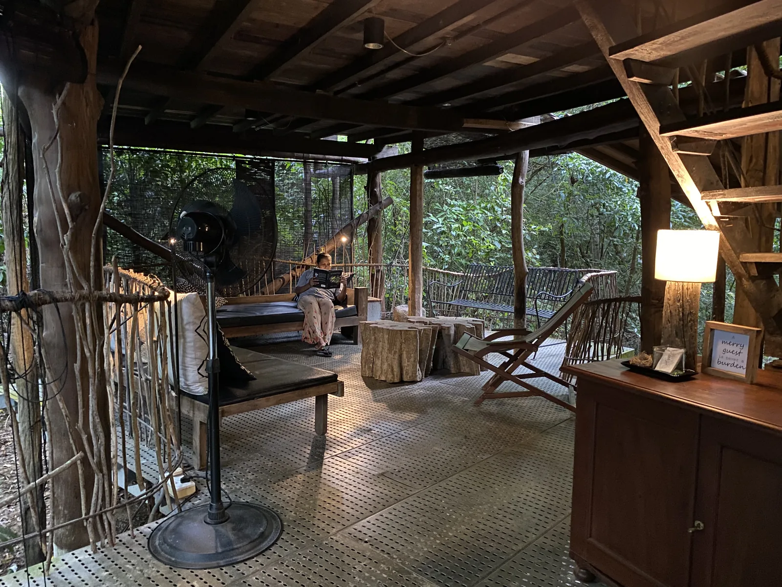The seating area on the deck of the second bungalow, with a daybed and stump table